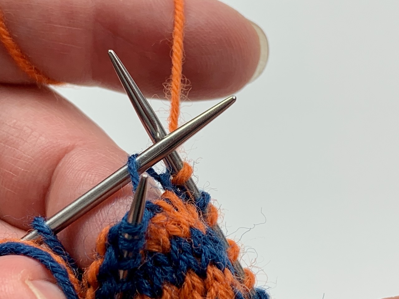 Masche aus dem Querfaden mit Neigung nach rechts zunehmen.