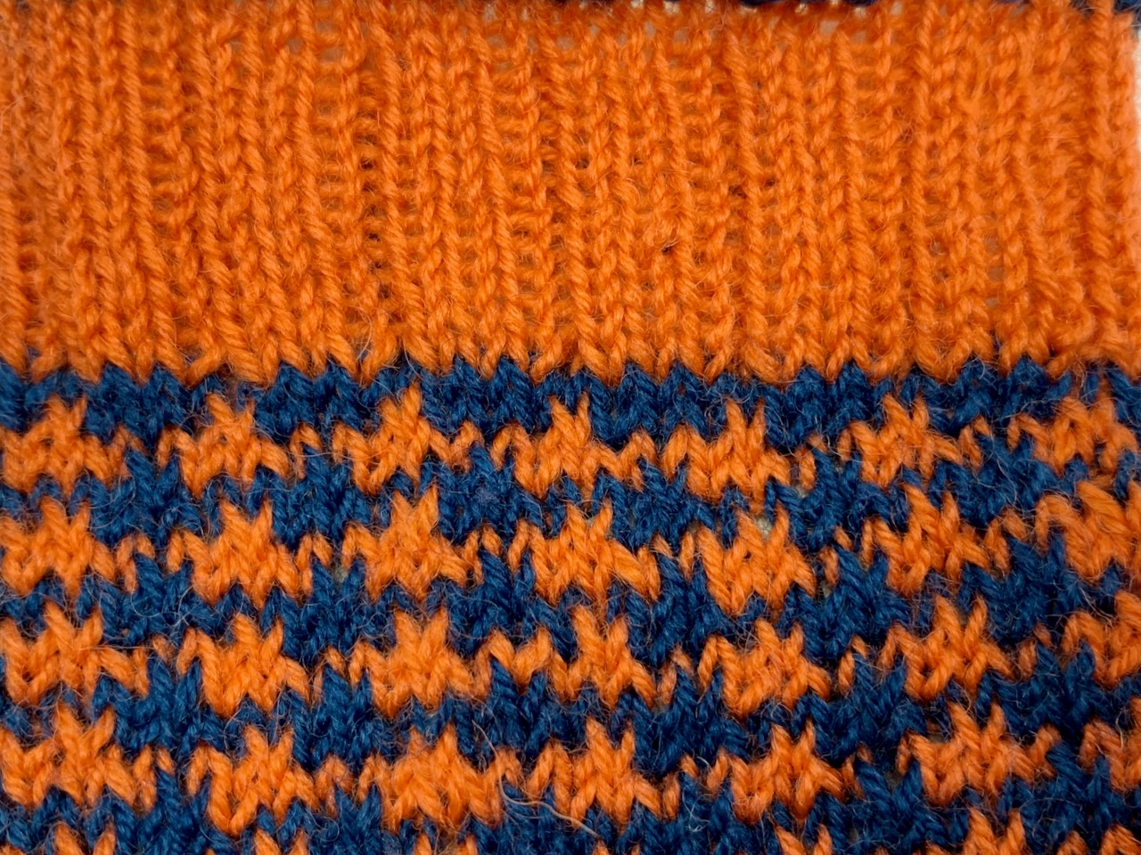 Toe-Up-Socken mit zweifarbiger Spitze - Die linken Maschen des Bündchens werden über die Hebemaschen des Schaftmusters in der Bündchenfarbe gestrickt.