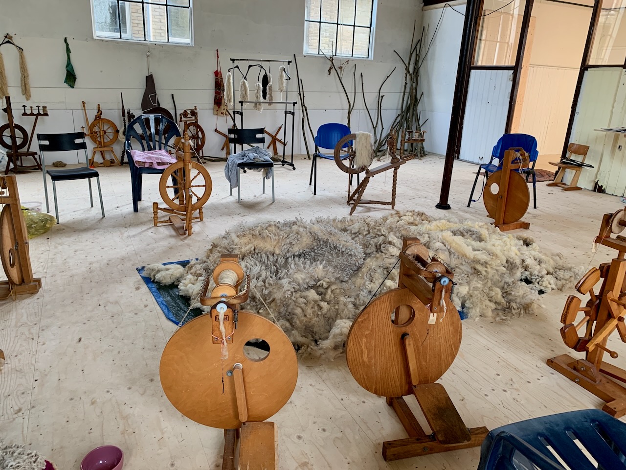 Im Kreis stehen Stühle und Spinnräder. Zu bestimmten Zeiten treffen sich die Bewohner und spinnen, stricken und klönen. So entsteht die Kathedrale aus Wolle in Gemeinschaftsarbeit.