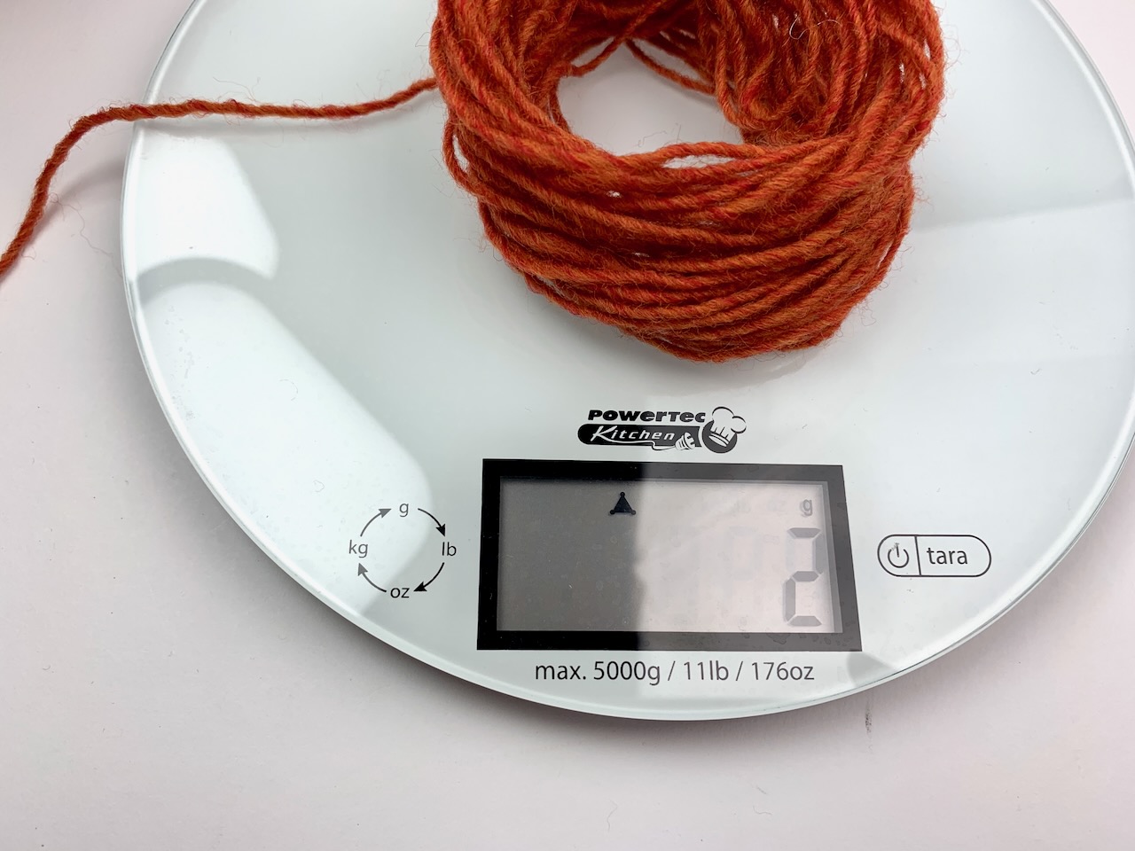 10 Meter Garn wird gewogen, um die Lauflänge zu berechnen