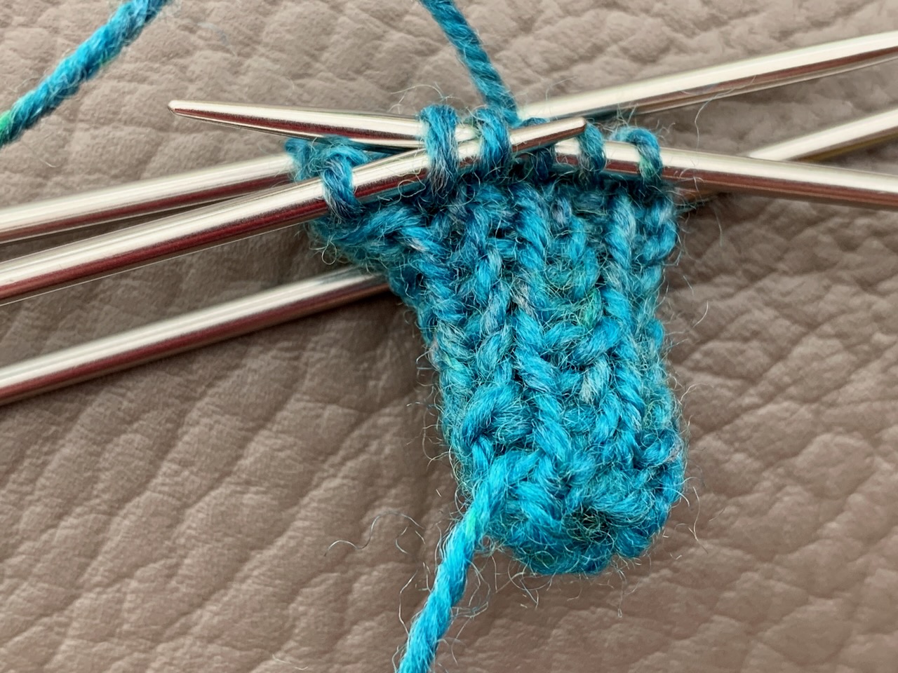 Minisocken stricken - auf Nadel 3 werden die 4 und 5 Masche per SSK zusammengestrickt.
